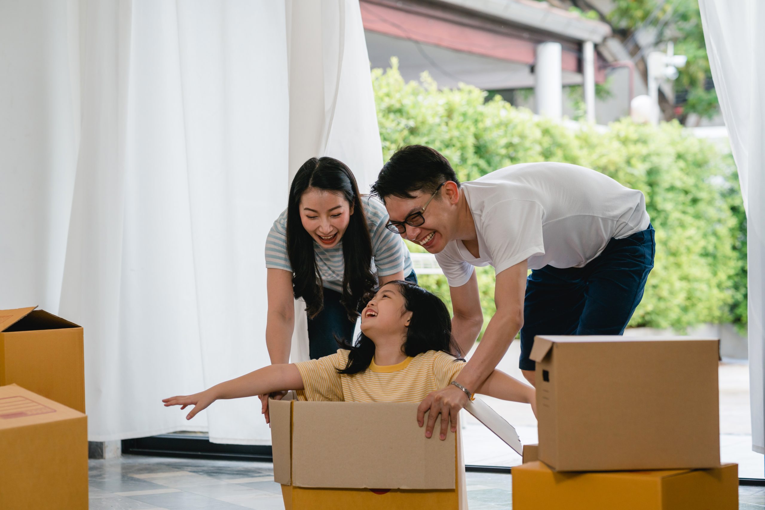 happy asian young family having fun laughing moving into new home japanese parents mother father scaled